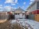 Backyard with partial snow cover, fenced yard, and small house at 805 S Lincoln St, Denver, CO 80209