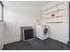 Laundry room with washer, black painted floor, shelving and natural light at 805 S Lincoln St, Denver, CO 80209