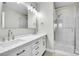 A well-lit bathroom featuring double sinks, vanity and a glass-enclosed shower at 1285 W 9Th Ave, Denver, CO 80204