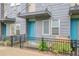 Charming townhome with blue door, gray siding, and landscaped front yard with black metal fencing at 1285 W 9Th Ave, Denver, CO 80204