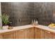 A home bar with a tiled feature wall and light wood cabinets with gold hardware at 5334 Sedona Dr, Parker, CO 80134