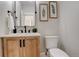 Stylish powder room with wood vanity, black hardware, and botanical wall art at 5334 Sedona Dr, Parker, CO 80134