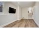 Finished basement living room with wood-look floors, tv, and stairs at 5334 Sedona Dr, Parker, CO 80134