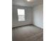 Carpeted bedroom bathed in natural light with a view of the street at 28624 E 7Th Ave, Watkins, CO 80137