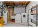 Basement laundry area features a washer, dryer, utility sink, and storage shelves at 12014 E Mexico Ave, Aurora, CO 80012
