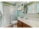 Bright bathroom featuring a glass enclosed shower and vanity with storage shelves at 12014 E Mexico Ave, Aurora, CO 80012