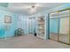 Bedroom with blue walls, shelving units, mirror door closets and carpet floors at 12014 E Mexico Ave, Aurora, CO 80012