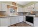 Functional kitchen featuring white cabinetry, appliances, and a window over the sink at 12014 E Mexico Ave, Aurora, CO 80012