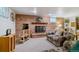 Living room with a brick fireplace, patterned sofa, and a TV on a wooden stand at 12014 E Mexico Ave, Aurora, CO 80012