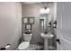 Small powder room includes framed art, pedestal sink, and low-flow toilet at 21916 E Swallow Pl, Aurora, CO 80016