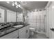 Well-lit bathroom featuring granite countertops, grey backsplash, shower and decorative shower curtain at 21916 E Swallow Pl, Aurora, CO 80016