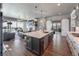Open concept kitchen overlooking the living room includes a center island with seating, stainless steel appliances, and barndoors at 21916 E Swallow Pl, Aurora, CO 80016