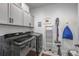 Clean and organized laundry room with modern washer and dryer set, storage cabinets, and convenient shelving at 21916 E Swallow Pl, Aurora, CO 80016