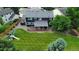 Aerial view of a spacious yard with a covered deck, ample green space, and surrounded by mature trees at 7404 La Quinta Ln, Lone Tree, CO 80124