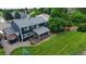 Aerial view of a home with a covered deck, a spacious grassy yard, and mature trees and landscaping at 7404 La Quinta Ln, Lone Tree, CO 80124