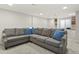 Finished basement offers a large gray sectional couch with blue patterned pillows for comfort at 7404 La Quinta Ln, Lone Tree, CO 80124