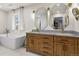Bright bathroom featuring a soaking tub, double vanity with granite counters, and modern fixtures at 7404 La Quinta Ln, Lone Tree, CO 80124