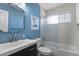 Stylish bathroom with blue walls, patterned tiles, a glass shower screen, and modern fixtures at 7404 La Quinta Ln, Lone Tree, CO 80124