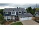 Charming two-story home featuring a three-car garage, blue siding, and brick accents, situated on a well-manicured lawn at 7404 La Quinta Ln, Lone Tree, CO 80124