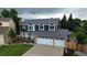 Desirable two-story home boasts a three-car garage, blue siding, and brick accents, complemented by a beautifully landscaped yard at 7404 La Quinta Ln, Lone Tree, CO 80124