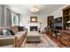 Inviting living room featuring a fireplace, hardwood floors and a large sectional sofa at 7404 La Quinta Ln, Lone Tree, CO 80124