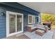Cozy outdoor patio with wicker furniture, sliding door, and blue exterior at 7404 La Quinta Ln, Lone Tree, CO 80124