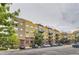 Condominium complex featuring yellow siding, brick accents, and balconies in a well-maintained community at 9019 E Panorama Cir # D504, Englewood, CO 80112