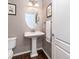 Powder room featuring a pedestal sink, decorative mirror and wood flooring at 3412 Valentia St, Denver, CO 80238