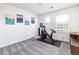 Spacious bedroom is equipped with a stationary bike, a large window, and is decorated with city skyline wall art at 3412 Valentia St, Denver, CO 80238