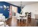 Dining area features hardwood floors, sliding door to patio, and elegant chandelier at 3412 Valentia St, Denver, CO 80238