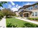 Inviting townhome featuring a well-manicured lawn, lush landscaping, and a sidewalk leading to a charming front entrance at 3412 Valentia St, Denver, CO 80238