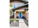 Inviting front porch with blue front door, stone columns, and seating, perfect for relaxing at 3412 Valentia St, Denver, CO 80238