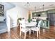 Open concept kitchen and dining area with hardwood floors and modern green cabinetry at 3412 Valentia St, Denver, CO 80238