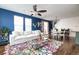 Inviting living area with dark blue accent wall, comfortable seating, and hardwood flooring at 3412 Valentia St, Denver, CO 80238