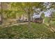 Lush backyard with mature trees, lawn, patio, and wooden deck at 106 Cherry St, Castle Rock, CO 80104