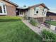 Charming home with lush green lawn, walkway, brick accents, and manicured landscaping at 6958 Brentwood Ct, Arvada, CO 80004