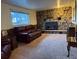 Cozy living room showcasing a stone fireplace, comfortable leather seating and neutral carpet at 6958 Brentwood Ct, Arvada, CO 80004
