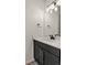 Bathroom vanity with a black cabinet, matte faucet and white countertop with a decorative sink at 12374 Farmview St, Thornton, CO 80241
