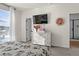 Bright bedroom featuring a sleek dresser, wall-mounted TV, and a window with sunny natural light at 12374 Farmview St, Thornton, CO 80241