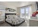 Comfortable bedroom featuring a stylish bed, bright natural light from the large window and decorative floral wall art at 12374 Farmview St, Thornton, CO 80241