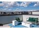 Rooftop patio offers stylish seating around a modern fire pit with a view of distant mountains and scattered clouds at 12374 Farmview St, Thornton, CO 80241
