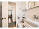All-white bathroom featuring a tiled vanity, sink, toilet, and mirror at 2361 Olive St, Denver, CO 80207