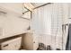 Well-lit bathroom with white tile, vanity, and a shower with a patterned curtain at 2361 Olive St, Denver, CO 80207