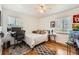 Bright bedroom with hardwood floors, ceiling fan, and two sunny windows at 2361 Olive St, Denver, CO 80207
