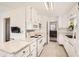 Bright kitchen with white cabinets, appliances, and marble countertops at 2361 Olive St, Denver, CO 80207