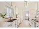 All-white kitchen featuring stainless steel sink, appliances, and marble countertops at 2361 Olive St, Denver, CO 80207