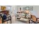 Open-concept living space with hardwood floors, neutral sofa, and a dining area with a wooden table at 2361 Olive St, Denver, CO 80207