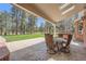 Back patio with a stone tile floor, an outdoor seating area, and a view of mature trees at 38666 County Road 21, Elizabeth, CO 80107