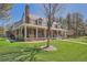 Charming two-story brick home featuring a spacious porch with classic columns, lush green lawn, and mature trees at 38666 County Road 21, Elizabeth, CO 80107