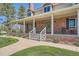 Inviting brick front porch with white columns and railing, offering ample space and a welcoming entrance at 38666 County Road 21, Elizabeth, CO 80107